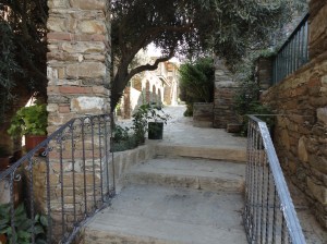 Stairway between stone column and wall beneath trees