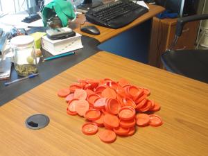 A heap of a hundred bottle-caps and five bottle-caps.