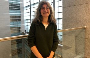 Ayşe poses at the railing above the atrium of the courthouse