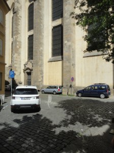 Cars parked between church buttresses