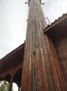 Seen from below, a wooden minaret appears as a triangle, transected by the line of a roof