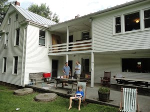 Three figures outside a white house