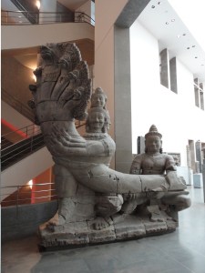 Many-headed man and and another man hold a many-headed serpent