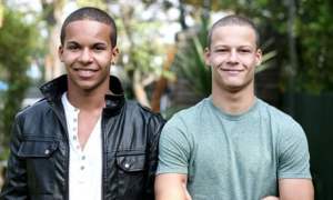 Two boys of similar builds, faces, and (short) haircuts, but different (smiling) expressions and skintones