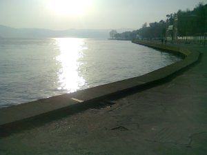 Sun reflected in strait and on a building in the distance