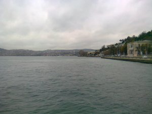 Water below, cloudy sky above, small building on right