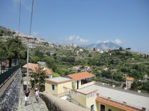 Photo: two figures climb stone stairs above houses on a hillside